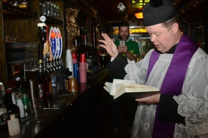 El sacerdote Chad Partain bendiciendo la cerveza.