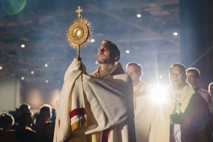 Un sacerdote bendiciendo con el Santísimo.
