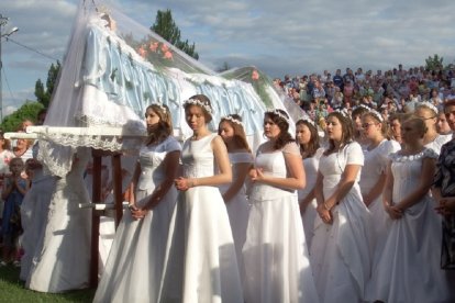 Chicas vestidas de novia llevan la imagen de la Virgen Dormida el día de la Asunción en Borek Stary, sur de Polonia