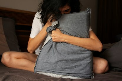Una mujer triste se abraza a una almohada