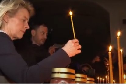 Ursula Von der Leyen en 2022, poniendo velas en una iglesia ucraniana por las masacres de Bucha