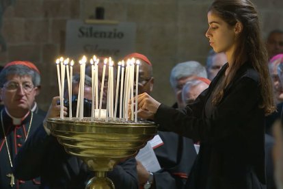 Una joven enciende velas