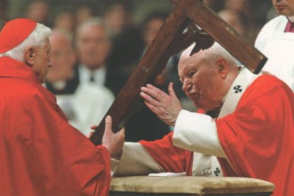 El Catecismo de la Iglesia Católica (1992), obra de una comisión coordinada por el cardenal Joseph Ratzinger (Benedicto XVI) y promulgado por San Juan Pablo II, incluye la realeza social de Cristo. En la imagen, uno entrega al otro la Cruz en el Viernes Santo de 2004.