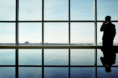Un hombre de negocios mirando por la ventana.