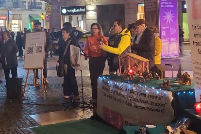Las letras de los villancicos en Plaza Sant Jaume se podían captar con un QR, la gente cantaba en la plaza mientras Collboni esconde el belén