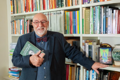 José María Goñi, autor de "La española de Montmartre", en su biblioteca, con un ejemplar de la novela en la mano.