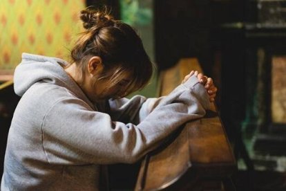 Una mujer centrada en oración en una iglesia, foto de Freepik
