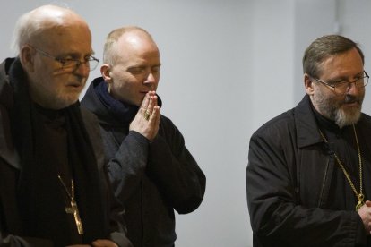 El cardenal Arborelius, junto con el obispo noruego Erik Varden y el arzobispo ucraniano Shevchuk, rezan ante la tumba del cardenal Husar en Kiev en 2023