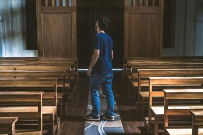 Un joven titubea en una iglesia, quizá dudando sobre confesarse...
