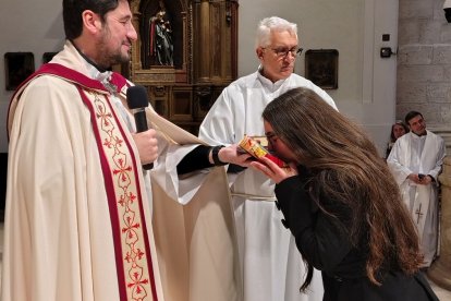 Una joven besa las Escrituras como parte de los Ritos de Ingreso al Catecumenado, en la catedral de la Magdalena de Getafe