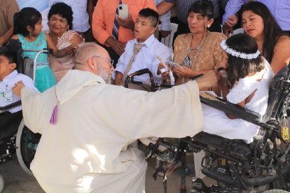 Hernández Belmonte, sacerdote misionero español en Piura, con unos niños en sillas de ruedas
