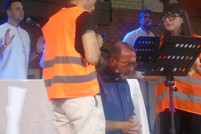 Antes de predicar el padre Pluchinotta, miembros de equipos de intercesión oran por él