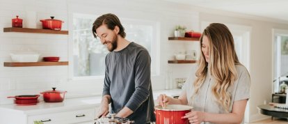 Una pareja cocinando felices.