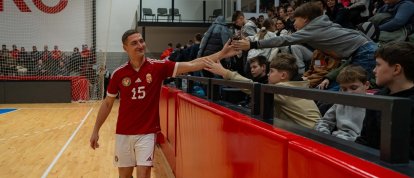 Un joven cura jugador de fútbol húngaro saluda al público del Campeonato Europeo de Fútbol Sala para Sacerdotes, en Hungría.