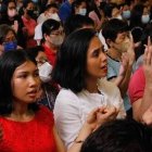 Filipinos en misa rezan con las manos levantadas el Padrenuestro