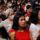 Filipinos en misa rezan con las manos levantadas el Padrenuestro