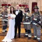 Eva y Daniel, tras casarse, rodeados de los bomberos que les ayudaron ante la alarma de incendios en una boda viral y considerada memorable.