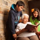 Una abuelita leyendo un libro a sus nietos