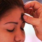 Una jóven recibe la ceniza de la conversión