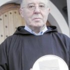 El padre Elías sostiene una reliquia, un mitón que ocultaba las manos heridas del santo capuchino