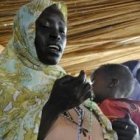 Una mamá sostiene a su bebé mientras reza el rosario