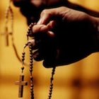 Una mujer sujeta un Rosario