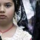 Pequeñas falleras llevan flores a la Virgen