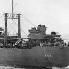 El padre Beda y el USS Jupiter, buque en el que sirvió como oficial durante la Segunda Guerra Mundial.