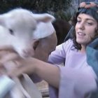 Una feligresa disfrazada de pastora pone un corderito sobre el Papa Francisco, que también es pastor