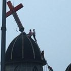 Unos operarios y una grúa retiran una cruz de una iglesia de Wenzhou por orden gubernamental