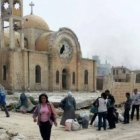 Cristianos greco-ortodoxos se acercan a lo que queda de su parroquia de San Elías en Qusayr, Homs