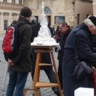 La asociación que fomenta la Columna Mariana recoge donativos con un sencillo tenderete en la plaza y un modelo y fotos del proyecto.