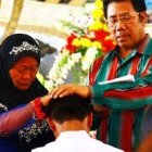 El nuevo sacerdote, bendecido por su madre y su padre adoptivo.