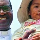El padre Kameni, misionero camerunés en Perú, con un niño de Santa Eulalia, zona dañada por graves riadas la pasada primavera