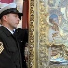 Clérigos y militares griegos veneran la Tricheroúsa de Monte Athos... la mano de metal a su pie recuerda el milagro de San Juan Damasceno
