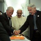 El padre Federico Lombardi (a la derecha) fue homenajeado con una tarta durante el vuelo de regreso de Cracovia, su último servicio como portavoz de la Santa Sede.
