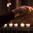 Un joven enciende velas en oración - la paciencia y la oración son las dos armas de quien intenta evangelizar, y más en su familia