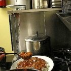 Don David, con el alzacuellos abierto por el calor, trabajando en los fogones de Communio.