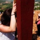 Una mujer en oración en la cruz de la Colina de las Apariciones de Medjugorje