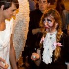 Night Fever en noche de Halloween en Valencia - Una evangelizadora vestida de ángel invita a orar con velitas en la iglesia a jóvenes vestidos de zombis