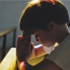 Un niño rezando en la iglesia