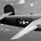 El diácono Jaime Bacas y uno de los aviones con la calavera de los Jolly Rogers en los que fue artillero en el Pacífico