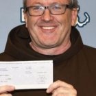 El padre Thomas Conway del santuario de San Antonio de Boston al cobrar el boleto de lotería