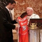 El capitán del Valencia, Rafa Martínez, da al cardenal Cañizares una camiseta para la Virgen de los Desamparados