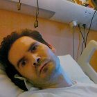 Vincent Lambert, en la cama del hospital, de la que cuelgan escapularios del Carmen. Sus padres son personas de profunda fe católica.