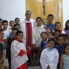 El padre Ignacio María Doñoro con niños del Hogar Nazaret tras recibir la capilla peregrina del Padre Pío llegada desde España