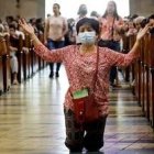 Una mujer reza en una iglesia de Asia... pero en varios países ya no es posible hacerlo en misa... Singapur e Italia, por ejemplo, y ahora Malasia