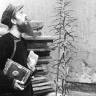 El misionero Leone Nani, con su cámara, asombrado ante una flor... quizá un símbolo de las misiones