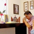 Una familia reza en su casa ante una imagen de la Virgen de Guadalupe