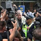 El cardenal Pell cuando llegaba a los juzgados y la prensa le atosigaba... el sistema legal australiano intenta evitar juicios paralelos en los medios